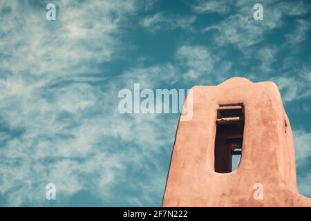 Torre di una vecchia chiesa storica di adobe in New Mexico con un cielo pittorico Foto Stock