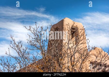 Torre di una vecchia chiesa storica di adobe in New Mexico con un cielo pittorico Foto Stock