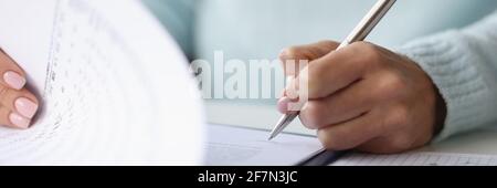 La mano della donna appone la firma sul closeup dei documenti Foto Stock