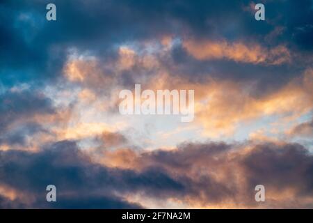 Colorato cielo nuvoloso sfondo, tramonto nuvoloso paesaggio con blu come cornice e giallo-arancio chiaro cielo al centro, astratto natura sfondo copia spazio. Foto Stock