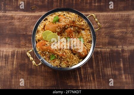 Biiriyani di pollo di Dum, immagine ravvicinata del biiriyani di talasseria di Kerala che è mescolato con masala e giallo nel colore disposto in una ciotola di servizio di rame Foto Stock