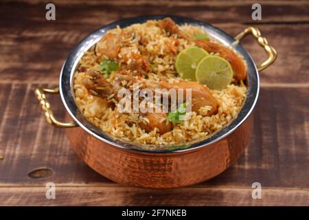 Biiriyani di pollo di Dum, immagine ravvicinata del biiriyani di talasseria di Kerala che è mescolato con masala e giallo nel colore disposto in una ciotola di servizio di rame Foto Stock