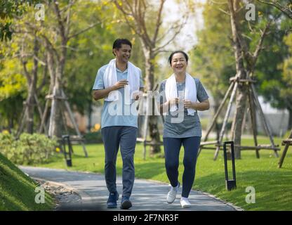 Sorridente coppia senior jogging, Senior coppia jogging e correre nel parco natura all'aperto Foto Stock