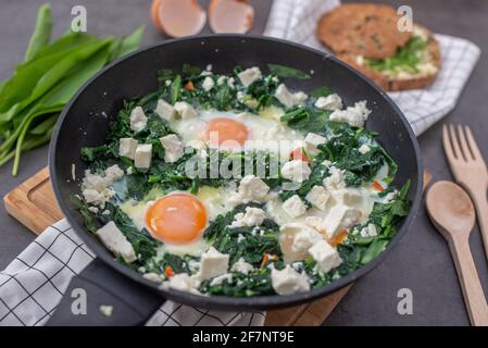 Shakshuka verde. Uova fritte con aglio selvatico e formaggio feta Foto Stock