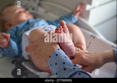 Madre che cambia pannolini di bambino piccolo cute ragazzo Foto Stock