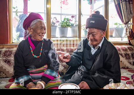 (210409) -- LHASA, 9 aprile 2021 (Xinhua) -- Ngawang Nyima chiacchiera con sua moglie nella loro residenza a Qamdo City, regione Autonoma del Tibet della Cina sudoccidentale, 18 febbraio 2021. Ngawang Nyima, 84 anni, è nato a Naixi Township, nella contea di Mangkam, nella città di Qamdo, nella regione autonoma del Tibet della Cina sudoccidentale, ed era un serf. Carico di pesanti tasse, iniziò a gregge di pecore per i padroni di casa quando non aveva più di otto anni, e fu costretto a prelevare il bittero da una salina del fiume Lancang. Il sentiero per la saliera era così precipitoso che un singolo passo incauto ne avrebbe rovesciato uno in rapide onde nel rive Foto Stock