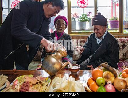 (210409) -- LHASA, 9 aprile 2021 (Xinhua) -- UN membro della famiglia serve tè tradizionale a Ngawang Nyima nella sua residenza nella città di Qamdo, regione Autonoma del Tibet della Cina sudoccidentale, 18 febbraio 2021. Ngawang Nyima, 84 anni, è nato a Naixi Township, nella contea di Mangkam, nella città di Qamdo, nella regione autonoma del Tibet della Cina sudoccidentale, ed era un serf. Carico di pesanti tasse, iniziò a gregge di pecore per i padroni di casa quando non aveva più di otto anni, e fu costretto a prelevare il bittero da una salina del fiume Lancang. Il sentiero verso la saliera era così precipitoso che un singolo passo incauto ne avrebbe rovesciato uno in rap Foto Stock