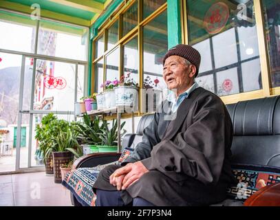 (210409) -- LHASA, 9 aprile 2021 (Xinhua) -- Ngawang Nyima si riposa nella sua residenza nella città di Qamdo, regione autonoma del Tibet della Cina sudoccidentale, 18 febbraio 2021. Ngawang Nyima, 84 anni, è nato a Naixi Township, nella contea di Mangkam, nella città di Qamdo, nella regione autonoma del Tibet della Cina sudoccidentale, ed era un serf. Carico di pesanti tasse, iniziò a gregge di pecore per i padroni di casa quando non aveva più di otto anni, e fu costretto a prelevare il bittero da una salina del fiume Lancang. Il sentiero per la saliera era così precipitoso che un singolo passo incauto si sarebbe rovesciato in rapide onde nel fiume. Ngawa Foto Stock