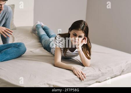 donna triste sdraiata sul letto in interni piena crescita Foto Stock