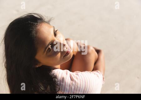 Vista ad alto angolo di una donna da corsa mista sorridente sulla spiaggia vacanze Foto Stock