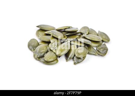 Semi di zucca isolati su sfondo bianco. Cumulo di semi di zucca verdi asciutti Foto Stock