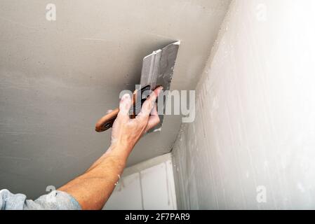 Cartongesso danneggiato con riparazione casa di uomo taglio cartongesso  cartongesso utilizzando utensili elettrici manuali angolari Foto stock -  Alamy