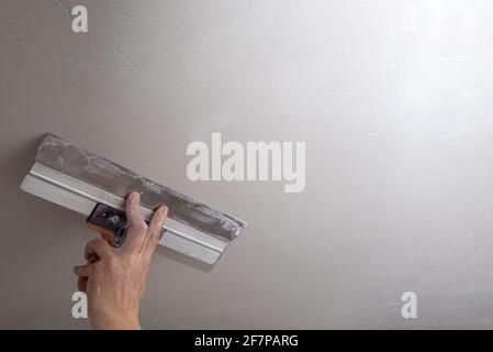 Casa danni interni per cartongesso con riparazione casa di uomo che taglia  cartongesso utilizzando utensili elettrici ad angolo Foto stock - Alamy