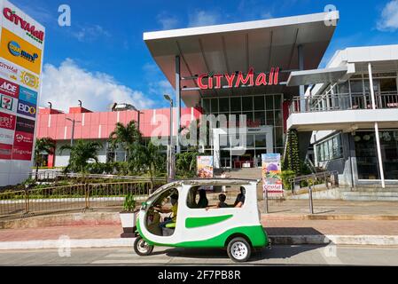 Un triciclo elettronico con passeggeri che aspettano di fronte al nuovo edificio City Mall sull'Isola di Boracay, Filippine, Asia Foto Stock