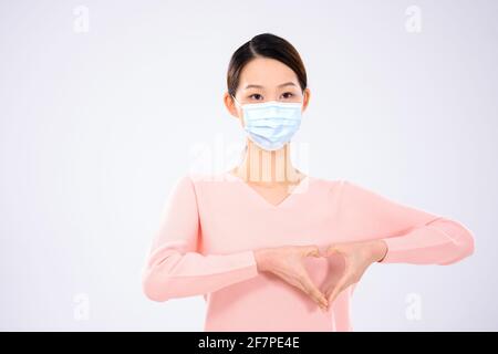 Una giovane donna che indossa una maschera vista frontale Foto Stock