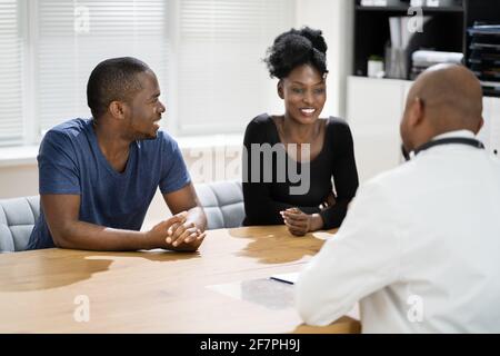 Felice African incinta coppia paziente al medico Foto Stock