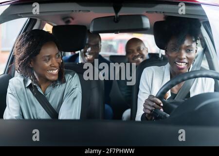 App servizio di condivisione carpool Ride. Gruppo di amici africani Foto Stock