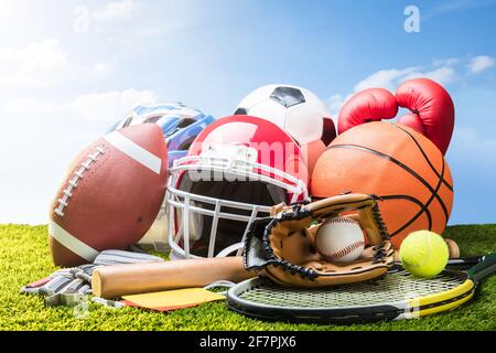 Varie attrezzature sportive e sfere su erba Foto Stock