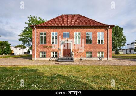 una piccola casa di mattoni rossi con una grande porta Foto Stock