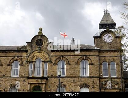 La bandiera di San Giorgio, a New Mills Town Hall Derbyshire, vola a pieno albero dopo l'annuncio di Buckingham Palace della morte del duca di Edimburgo cinque minuti più tardi è sostituito da una bandiera di Unione mezzo albero. Foto Stock