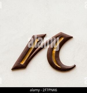 Lettera n in legno marrone minuscola con linee decorative dorate Foto Stock