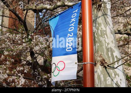 Un banner olimpico di Tokyo su un lampione e un albero di fiori di ciliegio in fiore nella zona di Waseda a Tokyo. (3/2021) Foto Stock