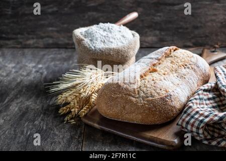 Pane fresco fatto in casa e farina in sacchetto piccolo burlap Foto Stock