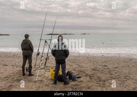 Owenahincha, West Cork, Irlanda. 9 Apr 2021. I residenti di Sandycove Steve McDonagh e William Browne, con il loro cane 'mussy', concedono un po' di pesca in mare in un caldo ma overcast pomeriggio a Owenahincha Beach. Credit: AG News/Alamy Live News Foto Stock