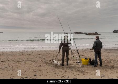 Owenahincha, West Cork, Irlanda. 9 Apr 2021. I residenti di Sandycove Steve McDonagh e William Browne, con il loro cane 'mussy', concedono un po' di pesca in mare in un caldo ma overcast pomeriggio a Owenahincha Beach. Credit: AG News/Alamy Live News Foto Stock