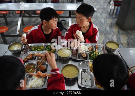 (210409) -- DENGFENG, 9 aprile 2021 (Xinhua) -- Liu Ziqian (TOP R) e Fang Yuhao (TOP L) della squadra di hockey su ghiaccio Shaolin Tagou cenano alla Scuola di Arti Marziali di Shaolin Tagou, Dengfeng City, provincia centrale di Henan, 31 marzo 2021. La Shaolin Tagou Martial Arts School, a pochi chilometri dal tempio Shaolin, luogo di nascita di Shaolin Kung fu, sta costruendo la sua squadra di hockey su ghiaccio. Gli studenti imparano lo sport sui pattini a rotelle in una pista di dimensioni standard coperta di pavimento, invece che di ghiaccio. Praticare le arti marziali rafforza i loro fisiques e fornisce loro le qualità atletiche che hocke ghiaccio Foto Stock