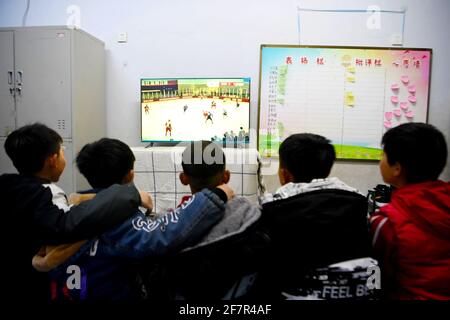 (210409) -- DENGFENG, 9 aprile 2021 (Xinhua) -- i giocatori della squadra di hockey su ghiaccio Shaolin Tagou guardano una partita di hockey su ghiaccio al loro dormitorio nella scuola di arti marziali di Shaolin Tagou, Dengfeng City, provincia centrale di Henan, 31 marzo 2021. La Shaolin Tagou Martial Arts School, a pochi chilometri dal tempio Shaolin, luogo di nascita di Shaolin Kung fu, sta costruendo la sua squadra di hockey su ghiaccio. Gli studenti imparano lo sport sui pattini a rotelle in una pista di dimensioni standard coperta di pavimento, invece che di ghiaccio. Praticare le arti marziali rafforza i loro fisiques e fornisce loro le qualità atletiche che hockey su ghiaccio Foto Stock