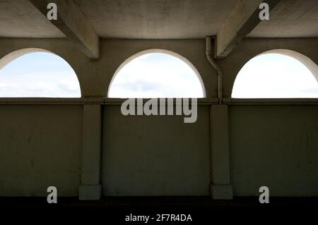 lunette aperture su una superficie di parete, guardando verso un cielo blu parzialmente nuvoloso Foto Stock