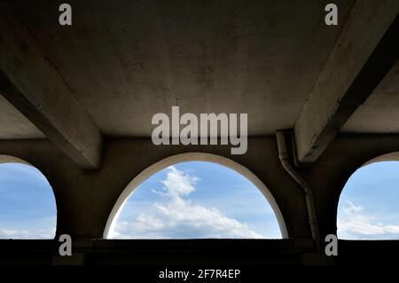 lunette aperture su una superficie di parete, guardando verso un cielo blu parzialmente nuvoloso Foto Stock