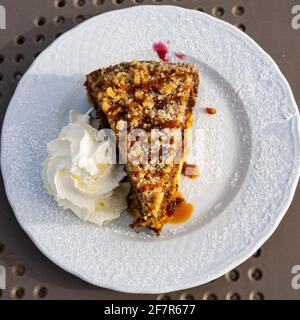 Piatto in porcellana con una fetta di torta di carote con panna Foto Stock