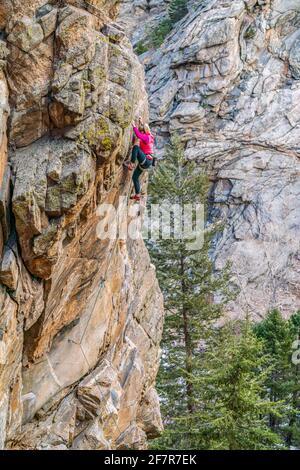 Donna rock climber la naviga su una parete rocciosa in Golden, CO Foto Stock