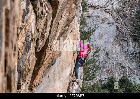 Donna rock climber la naviga su una parete rocciosa in Golden, CO Foto Stock