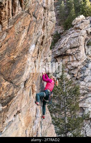 Donna rock climber la naviga su una parete rocciosa in Golden, CO Foto Stock