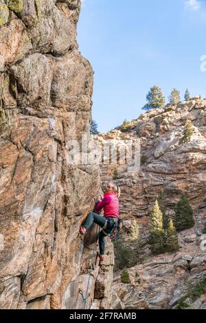 Donna rock climber la naviga su una parete rocciosa in Golden, CO Foto Stock