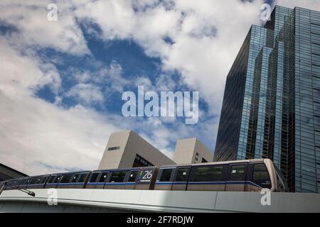 Vista orizzontale a basso angolo del New Transit Yurikamome (il primo sistema di transito completamente automatizzato di Tokyo) che viaggia sull'isola di Odaiba, Tokyo, Giappone Foto Stock