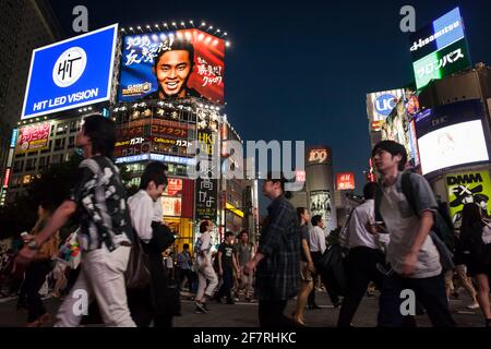 Vista orizzontale ad angolo basso del traffico pedonale e del trambusto di Shibuya Crossing di notte, Shibuya, Tokyo, Giappone Foto Stock