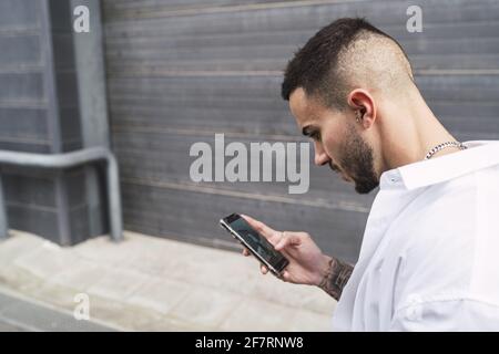 Spagnolo maschio usando il suo telefono all'aperto Foto Stock