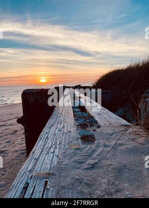 Una vista ad angolo basso del tramonto nel tardo pomeriggio sulla Baia di Delaware dalla riva nord di Cape May. Foto Stock