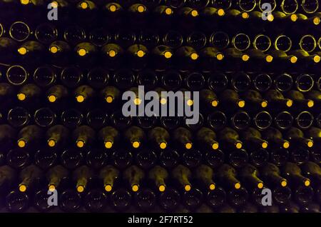 Bottiglie di vino conservate nella cantina sotterranea per l'invecchiamento. Foto Stock