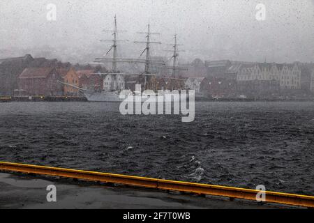 Nave a vela a pieno regime Christian Radich (costruito nel 1937) in una tempesta di neve. Alla banchina di Bryggen, nel vecchio porto di Bergen, Norvegia. Foto Stock