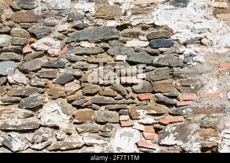 Primo piano di vecchie pareti in pietra fatte di rocce colorate accatastate uno sull'altro Foto Stock