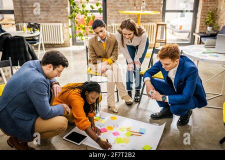 Responsabili di progetto e dipendenti che si occupano di brainstorming sulle idee - Gruppo multietnico dei lavoratori che hanno una riunione di affari in un ufficio di start-up Foto Stock