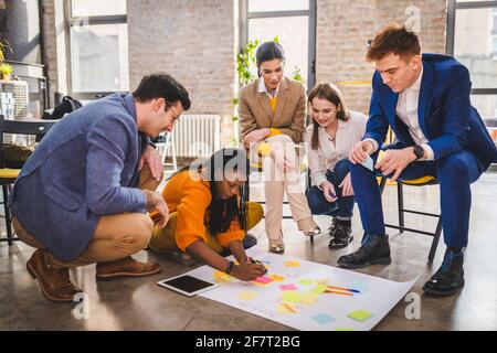 Responsabili di progetto e dipendenti che si occupano di brainstorming sulle idee - Gruppo multietnico dei lavoratori che hanno una riunione di affari in un ufficio di start-up Foto Stock