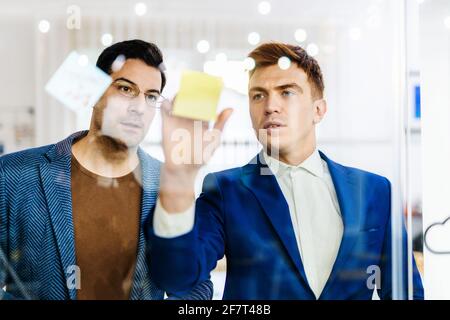 Responsabili di progetto e dipendenti che si occupano di brainstorming sulle idee - Gruppo multietnico dei lavoratori che hanno una riunione di affari in un ufficio di start-up Foto Stock