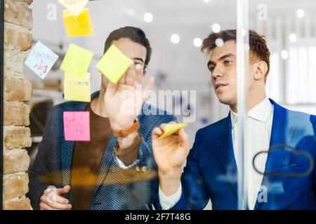 Responsabili di progetto e dipendenti che si occupano di brainstorming sulle idee - Gruppo multietnico dei lavoratori che hanno una riunione di affari in un ufficio di start-up Foto Stock