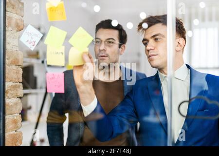 Responsabili di progetto e dipendenti che si occupano di brainstorming sulle idee - Gruppo multietnico dei lavoratori che hanno una riunione di affari in un ufficio di start-up Foto Stock